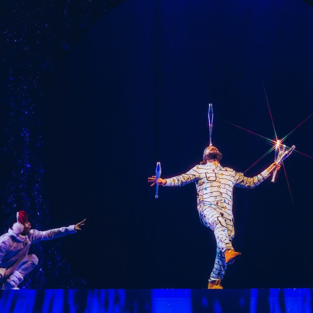 Performer balancing stick on nose while juggling - Cirque Chicago